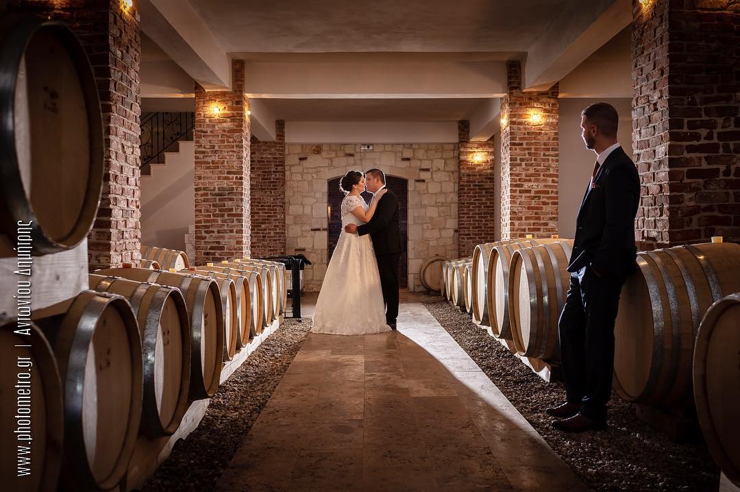 Couple embracing among wine barrels in a cellar