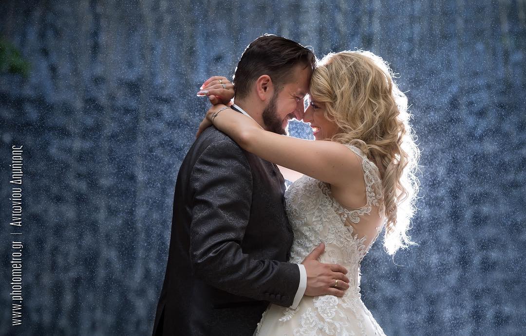 Bride and groom laughing together in the rain