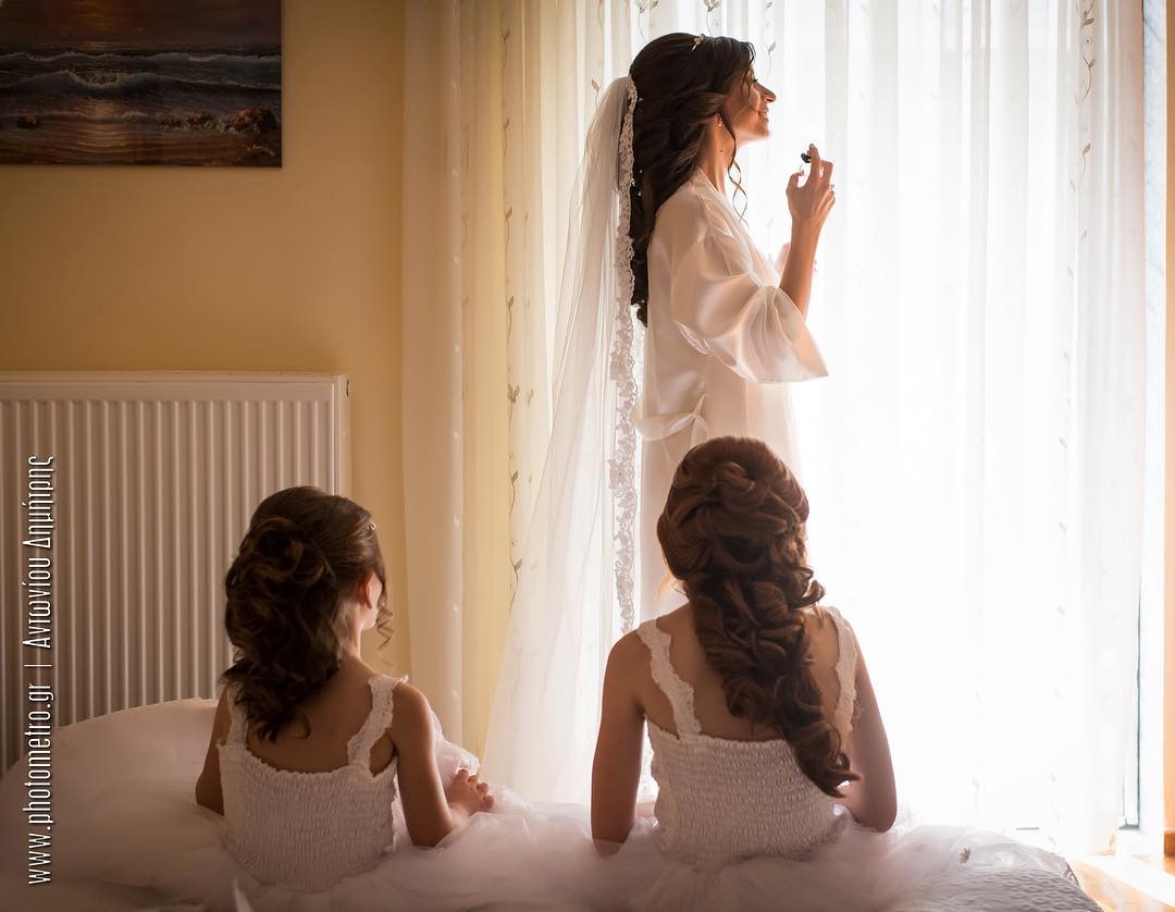 Bride and flower girls looking out the window